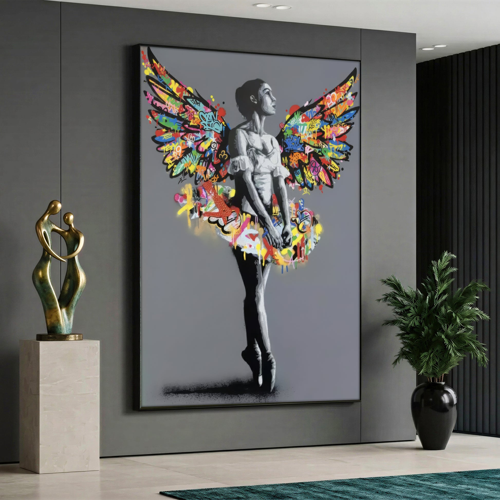 A street art style canvas painting depicting a monochrome black and white ballerina standing on her toes against a solid grey background, featuring a tutu and large angel wings covered in vibrant, multicolored graffiti and splashes of paint.