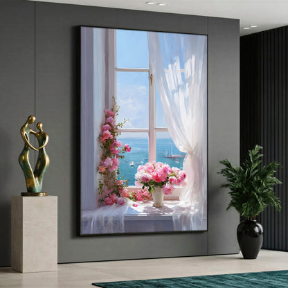 A view through an open white window showing a blue sea with boats, featuring a vase of pink roses and climbing pink flowers on the windowsill next to a blowing white sheer curtain.