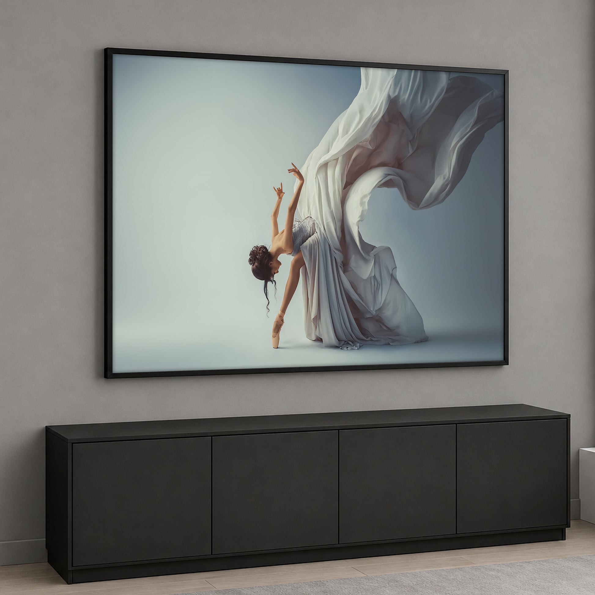 A graceful female ballerina dancing on pointes with a large, flowing dramatic white fabric behind her against a light gray background.